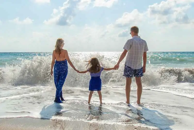 A family walking through water at the beach